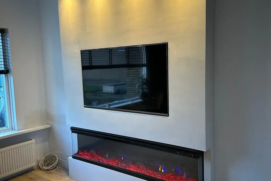 Cinewall met tv boven een brede elektrische sfeerhaard en inbouwspots