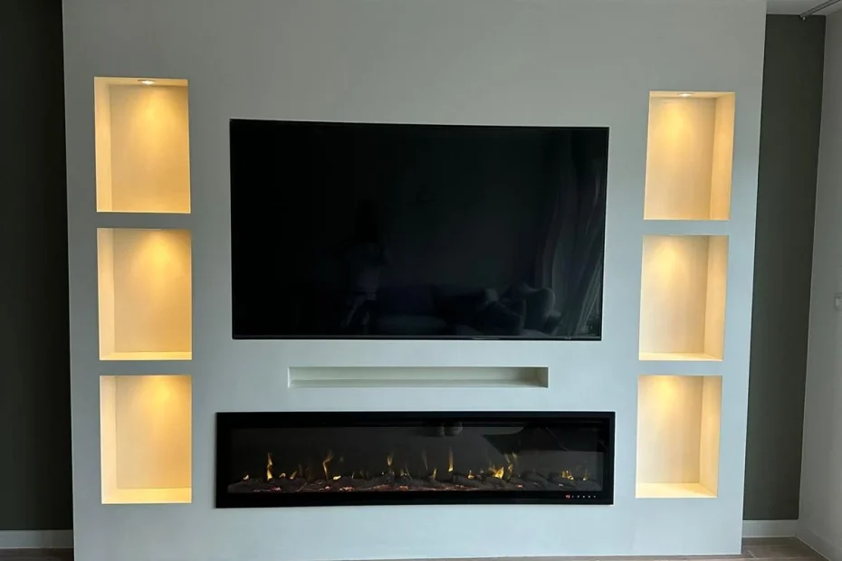 Witte cinewall met verlichte nissen en brede elektrische sfeerhaard boven een houten vloer